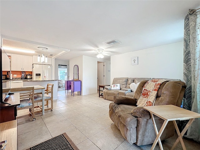 living room featuring ceiling fan with notable chandelier and light tile patterned floors