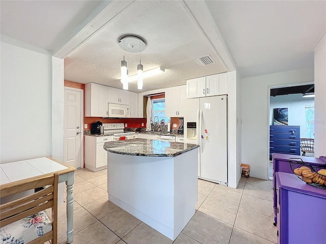 kitchen with hanging light fixtures, white cabinets, white appliances, a center island, and dark stone countertops