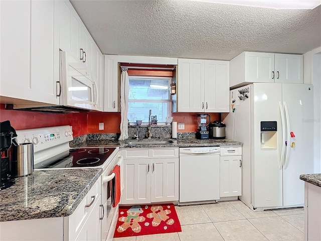 kitchen featuring sink, white cabinets, light tile patterned floors, white appliances, and a textured ceiling