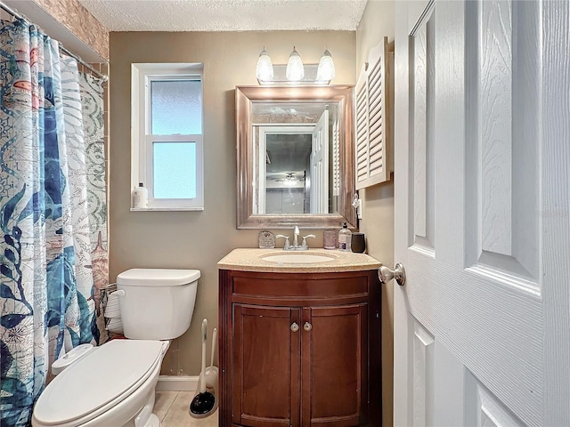 bathroom with vanity, toilet, tile patterned floors, and a textured ceiling