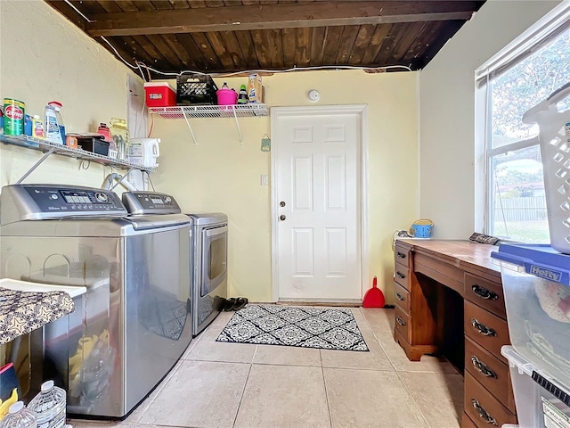 clothes washing area featuring separate washer and dryer, wood ceiling, and a healthy amount of sunlight