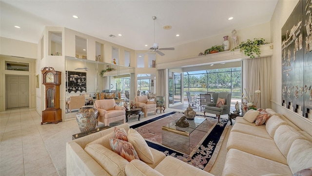 living room with a towering ceiling, a healthy amount of sunlight, and light tile patterned floors