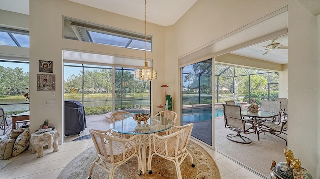 tiled dining space featuring a water view and ceiling fan