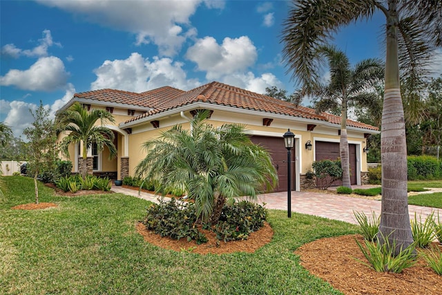 mediterranean / spanish house with a garage and a front yard