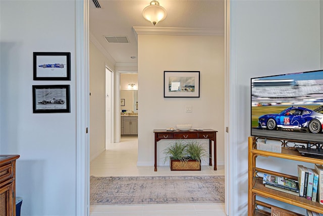 hallway featuring crown molding and light tile patterned flooring