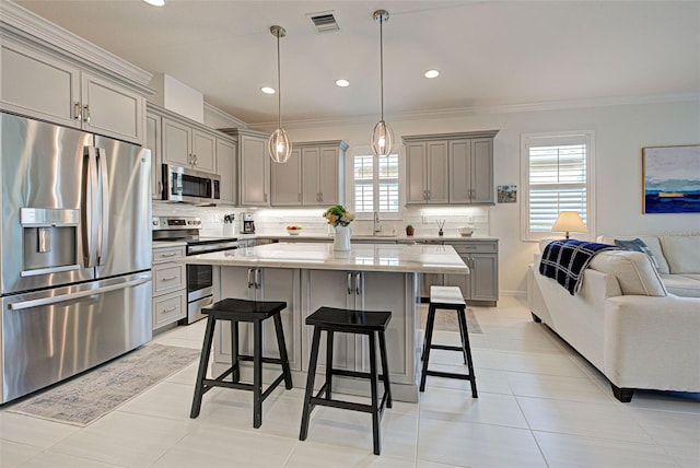 kitchen featuring pendant lighting, stainless steel appliances, a center island, and a breakfast bar area