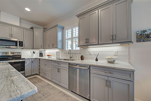 kitchen with stainless steel appliances, light stone countertops, sink, and backsplash