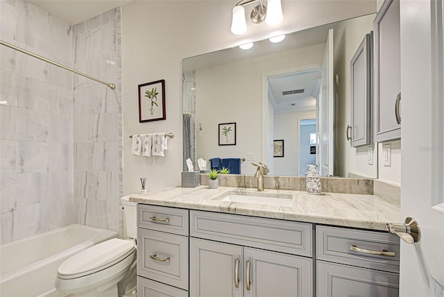 full bathroom featuring vanity, tiled shower / bath combo, and toilet