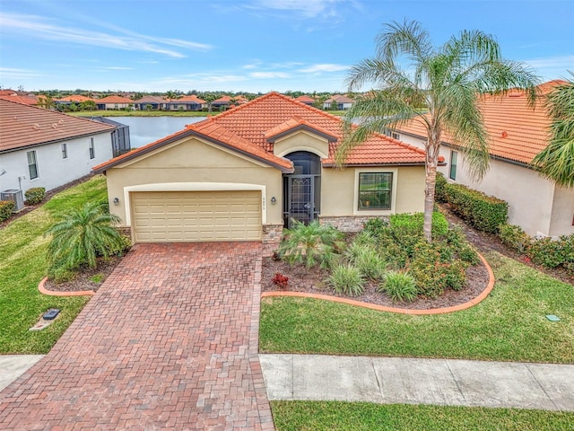 mediterranean / spanish-style house featuring a garage, a water view, and a front yard