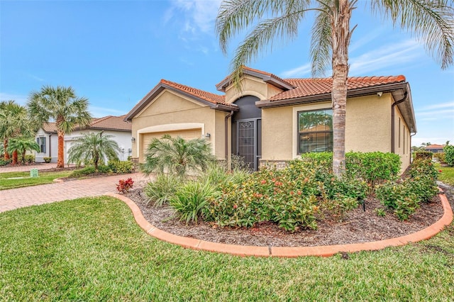 mediterranean / spanish-style house featuring a garage and a front lawn