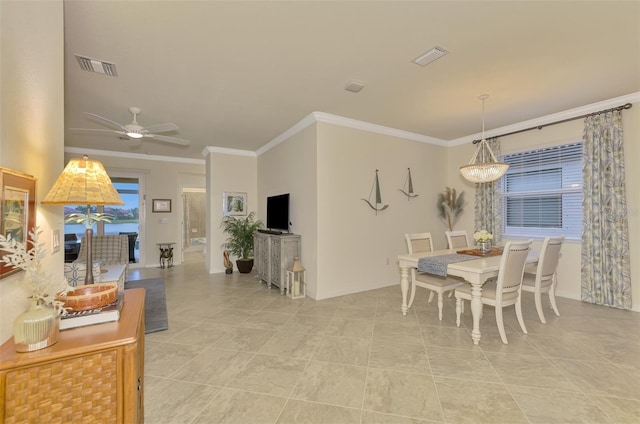 tiled dining area featuring ornamental molding and ceiling fan