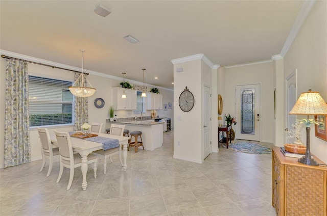 dining room featuring sink and crown molding