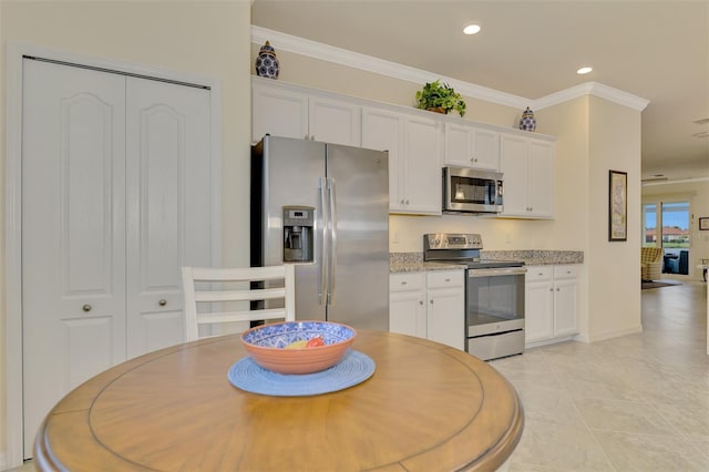 kitchen featuring white cabinetry, ornamental molding, and appliances with stainless steel finishes