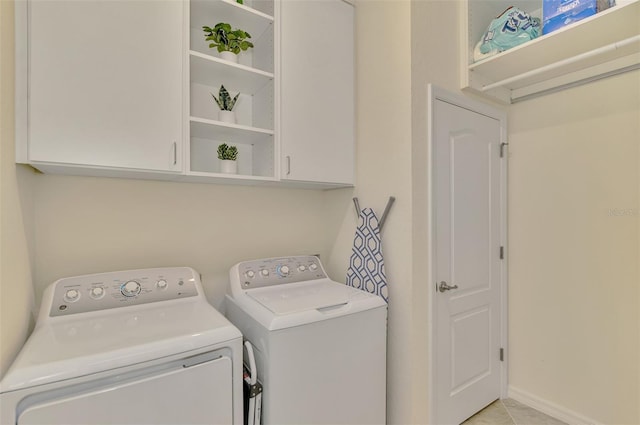 washroom featuring cabinets, light tile patterned flooring, and independent washer and dryer