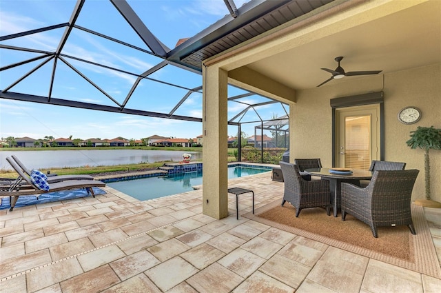 view of swimming pool featuring ceiling fan, a water view, glass enclosure, and a patio area