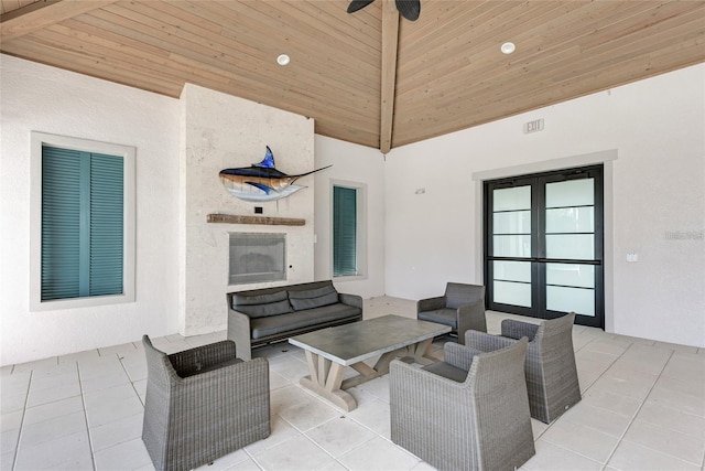 view of patio / terrace with ceiling fan, french doors, and an outdoor living space with a fireplace