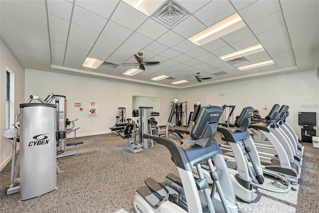 gym featuring ceiling fan, a paneled ceiling, and a raised ceiling