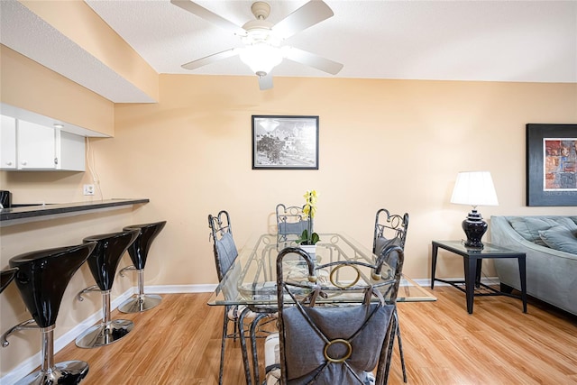 dining area with light hardwood / wood-style flooring and ceiling fan