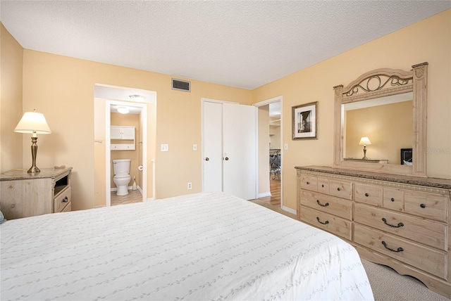 bedroom featuring carpet flooring, connected bathroom, a textured ceiling, and a closet