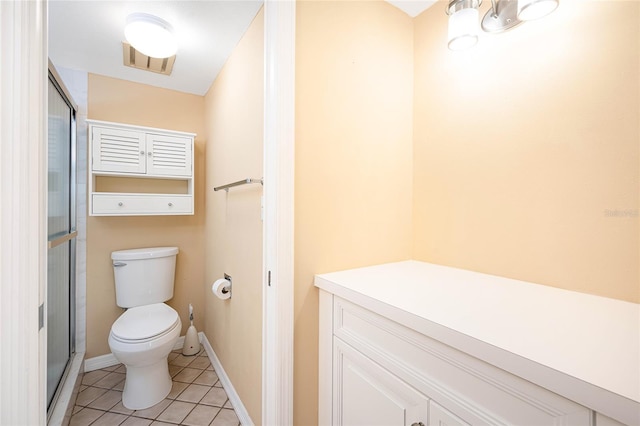 bathroom featuring tile patterned flooring, toilet, and walk in shower