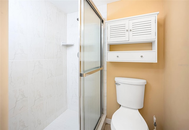 bathroom with a shower with door and toilet