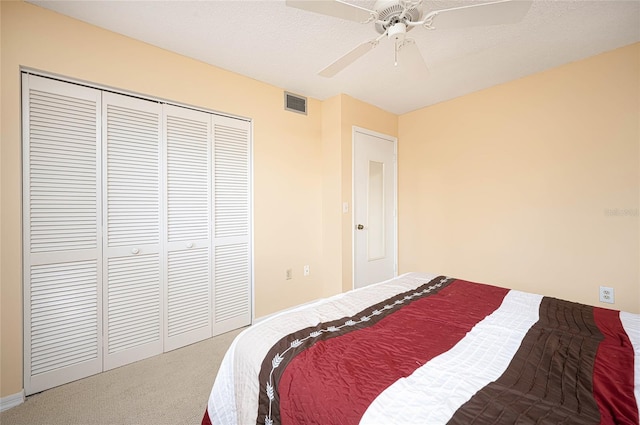 carpeted bedroom featuring ceiling fan and a closet