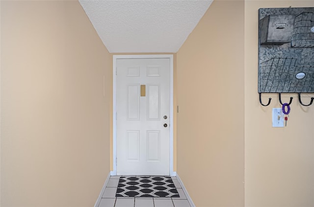 doorway featuring tile patterned flooring and a textured ceiling