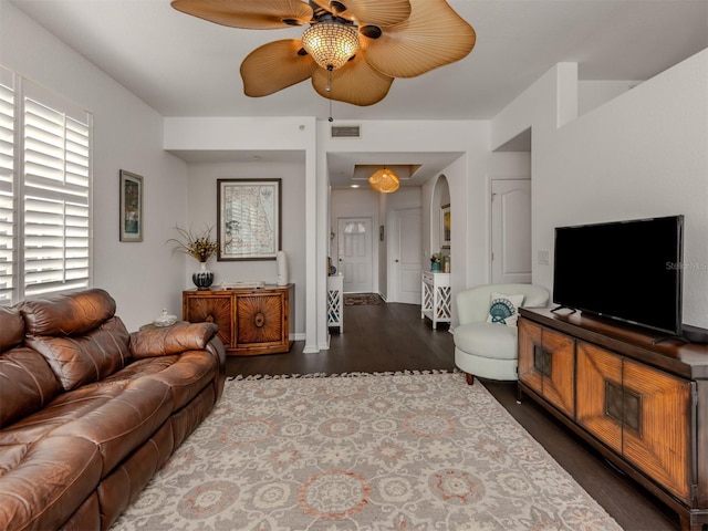 living room featuring ceiling fan and dark wood-type flooring