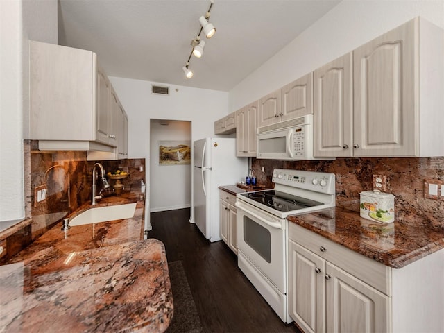 kitchen featuring sink, dark wood-type flooring, dark stone counters, white appliances, and decorative backsplash