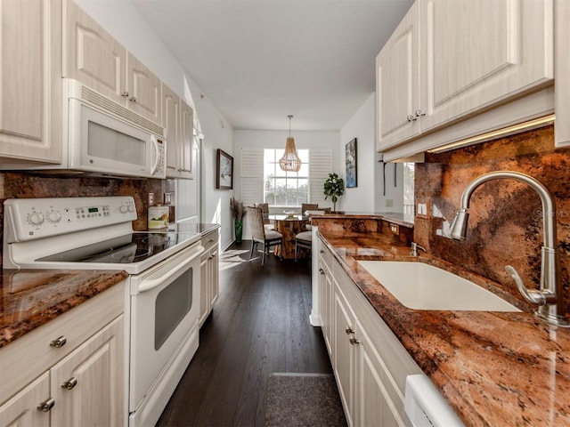 kitchen with sink, white appliances, decorative backsplash, and dark stone countertops