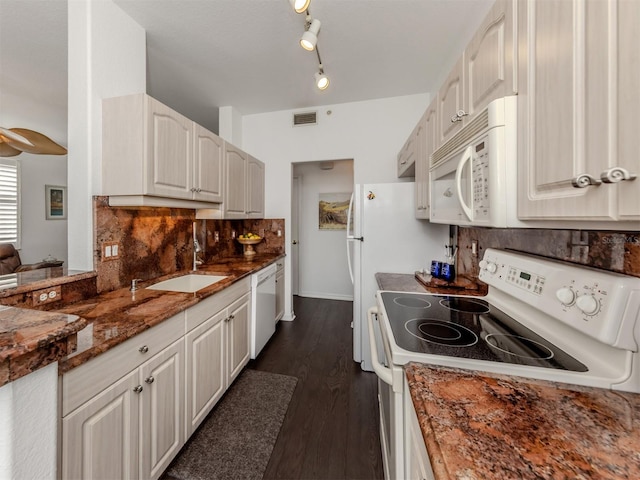 kitchen featuring white appliances, white cabinetry, tasteful backsplash, dark stone countertops, and sink