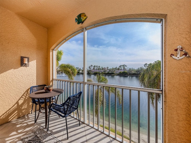 sunroom featuring a water view