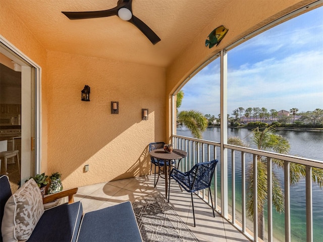 balcony featuring ceiling fan and a water view