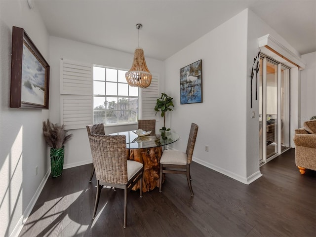 dining space featuring dark hardwood / wood-style floors and a notable chandelier