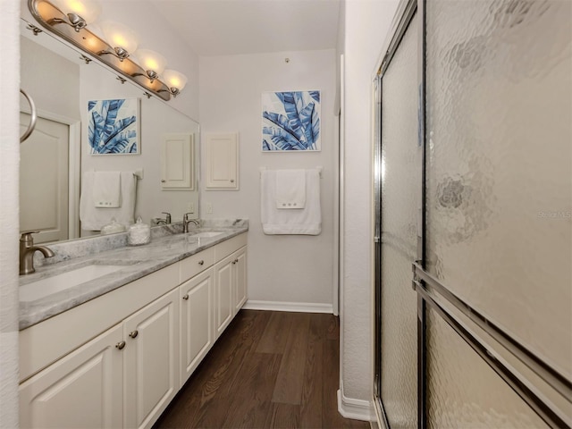 bathroom featuring hardwood / wood-style flooring, an enclosed shower, and vanity