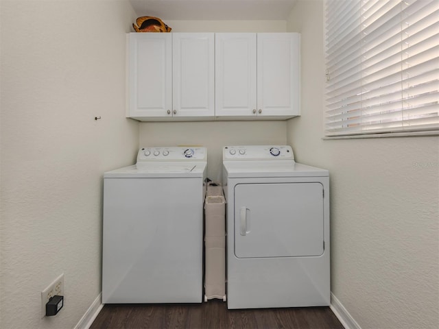 clothes washing area featuring washer and clothes dryer, dark hardwood / wood-style flooring, and cabinets