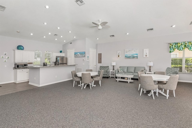 carpeted dining room featuring ceiling fan, vaulted ceiling, electric panel, and a healthy amount of sunlight