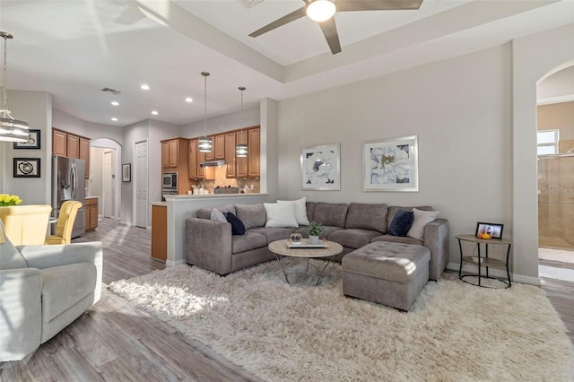 living room with light wood-type flooring and ceiling fan