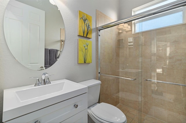 bathroom with toilet, a shower with door, and vanity