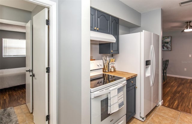 kitchen featuring white appliances, wooden counters, ceiling fan, gray cabinetry, and light tile patterned flooring