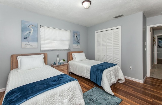 bedroom featuring dark hardwood / wood-style floors, a closet, and a textured ceiling