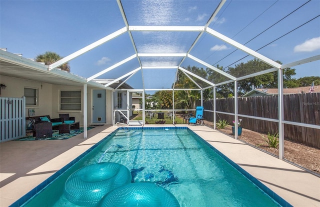 view of swimming pool featuring a patio, an outdoor hangout area, and glass enclosure