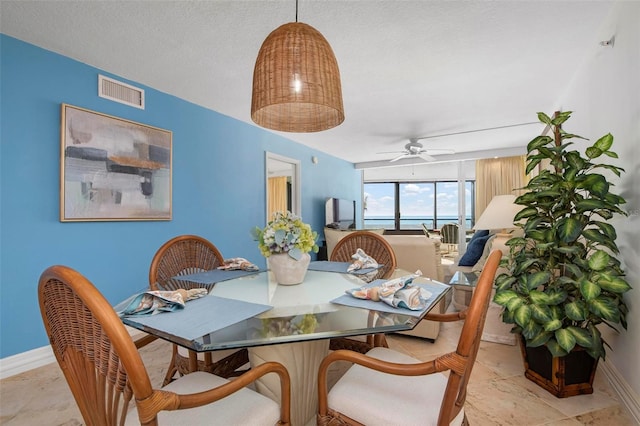 dining room with ceiling fan and a textured ceiling