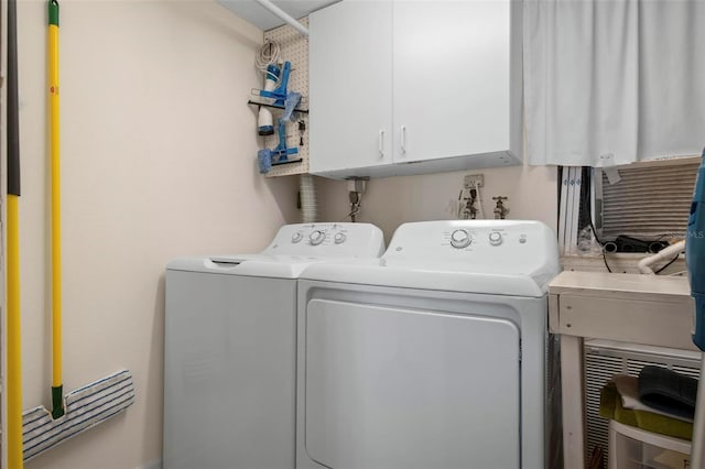 laundry area with washer and dryer and cabinets