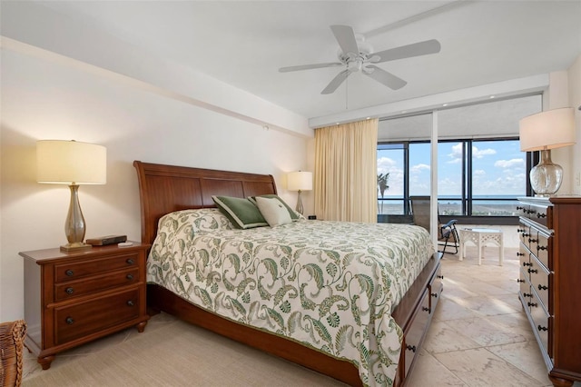 bedroom with ceiling fan, baseboard heating, access to exterior, floor to ceiling windows, and a water view