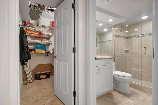 bathroom featuring walk in shower, vanity, and toilet