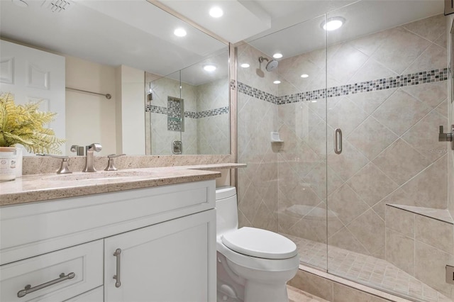 bathroom with walk in shower, vanity, and toilet