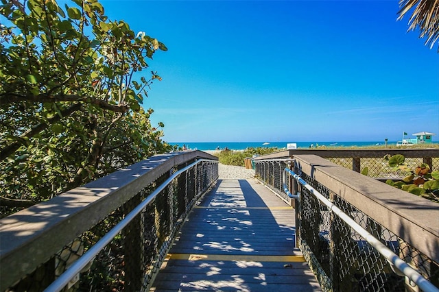 view of home's community with a water view and a beach view