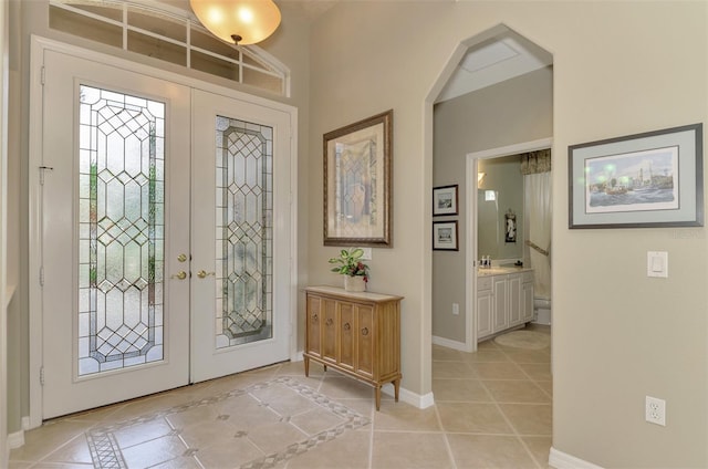 entryway featuring light tile patterned floors, french doors, and sink