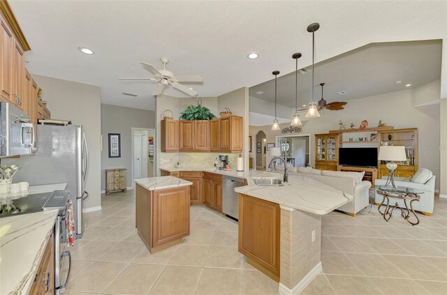 kitchen featuring ceiling fan, appliances with stainless steel finishes, kitchen peninsula, and a center island